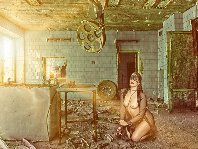 Fotokunst mit einer sitzenden Figur in einer verlassen wirkenden Werkhalle.