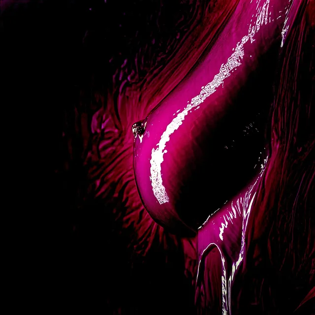 Detailaufnahme eines pinkfarbenen Mundes mit einem glänzenden Tropfen.